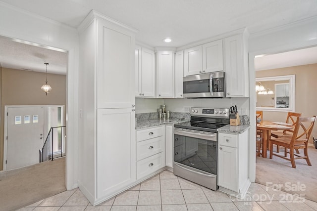 25 Hazel Ct, Brevard, NC 28712 - kitchen with appliances with stainless steel finishes, white cabinets, light stone countertops, light tile patterned flooring, and ornamental molding