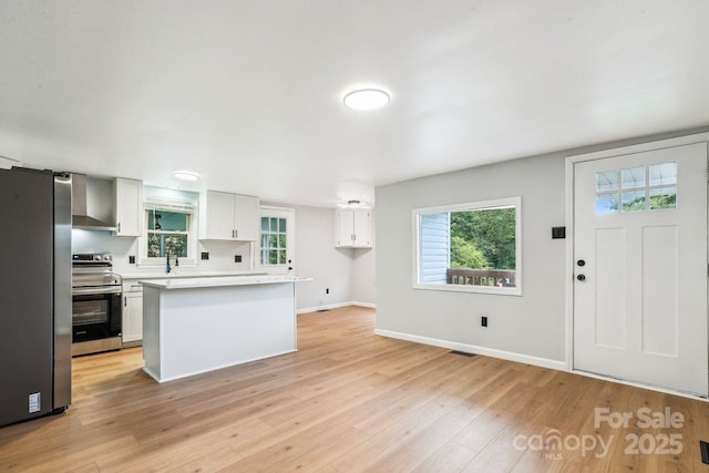201 Hoyle Cir, Gastonia, NC 28052 - kitchen featuring stainless steel appliances, light countertops, light wood-style floors, white cabinetry, and a center island
