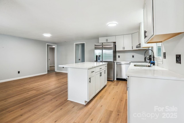 201 Hoyle Cir, Gastonia, NC 28052 - kitchen featuring appliances with stainless steel finishes, a center island, light countertops, white cabinetry, and light wood finished floors