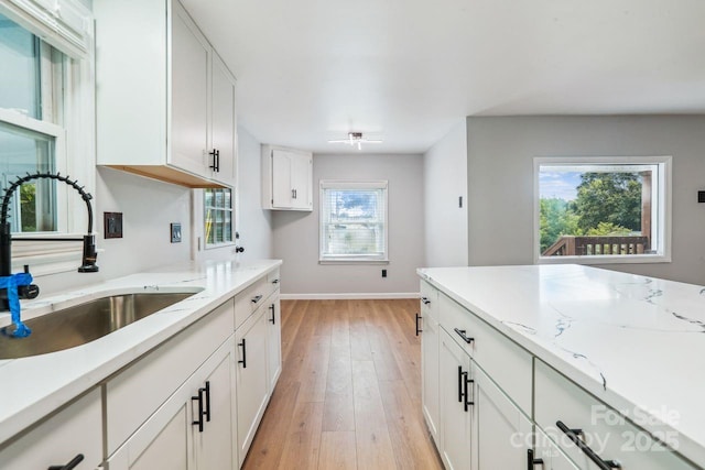 201 Hoyle Cir, Gastonia, NC 28052 - kitchen with light wood-type flooring, white cabinetry, and light stone counters