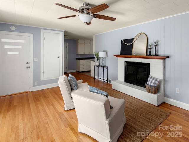30 Belleview Rd, Waynesville, NC 28786 - living area featuring a ceiling fan, light wood finished floors, a brick fireplace, and ornamental molding