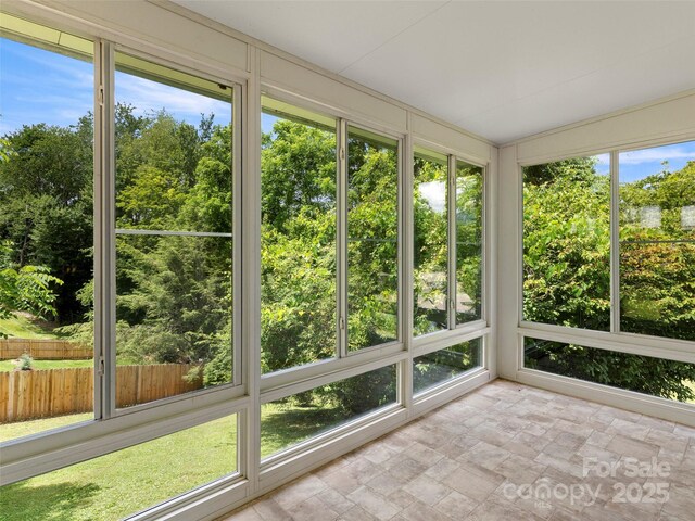 30 Belleview Rd, Waynesville, NC 28786 - unfurnished sunroom featuring stone finish flooring and view of wooded area