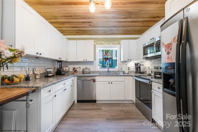 1114 Mountain St, Kannapolis, NC 28081 - kitchen featuring appliances with stainless steel finishes, wooden ceiling, light wood-style floors, white cabinetry, and tasteful backsplash