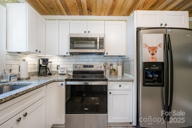1114 Mountain St, Kannapolis, NC 28081 - kitchen with appliances with stainless steel finishes, wood ceiling, white cabinets, and backsplash
