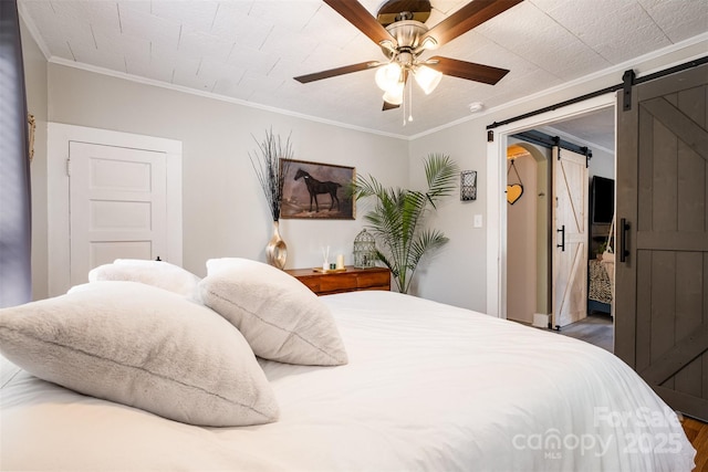 1114 Mountain St, Kannapolis, NC 28081 - bedroom featuring a barn door, wood finished floors, ornamental molding, and a ceiling fan