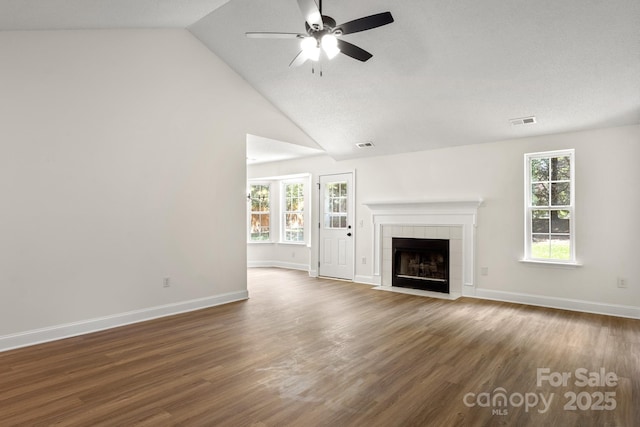 2210 Dawn Rdg, Monroe, NC 28110 - unfurnished living room with ceiling fan, a tile fireplace, wood finished floors, plenty of natural light, and vaulted ceiling