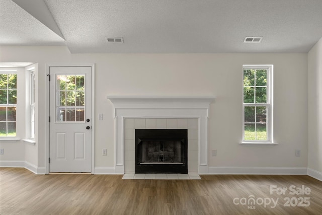 2210 Dawn Rdg, Monroe, NC 28110 - unfurnished living room featuring wood finished floors, plenty of natural light, and a textured ceiling