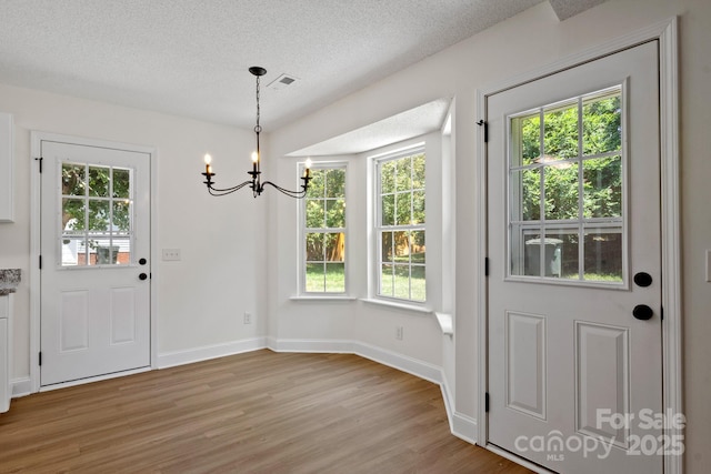 2210 Dawn Rdg, Monroe, NC 28110 - entrance foyer featuring a chandelier, light wood-type flooring, plenty of natural light, and a textured ceiling
