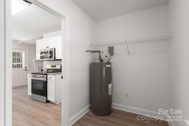 2210 Dawn Rdg, Monroe, NC 28110 - laundry room with water heater and light wood finished floors