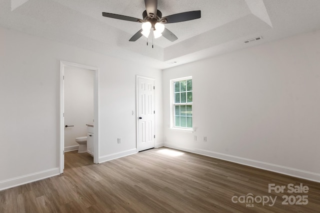 2210 Dawn Rdg, Monroe, NC 28110 - unfurnished bedroom featuring wood finished floors, a raised ceiling, ensuite bathroom, and ceiling fan