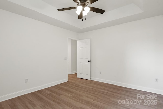 2210 Dawn Rdg, Monroe, NC 28110 - empty room with wood finished floors, ceiling fan, and a tray ceiling