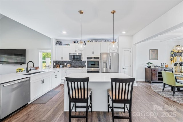 1302 Black Walnut St, Monroe, NC 28112 - kitchen with stainless steel appliances, light countertops, a center island, tasteful backsplash, and white cabinetry