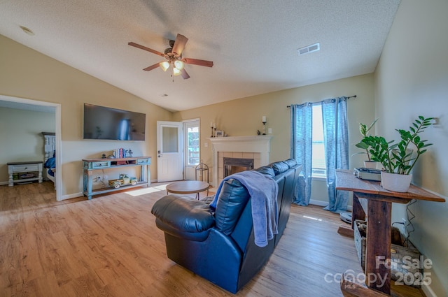 1975 8th Street Ln SE, Hickory, NC 28602 - living area featuring ceiling fan, a fireplace, light wood-style floors, a textured ceiling, and lofted ceiling
