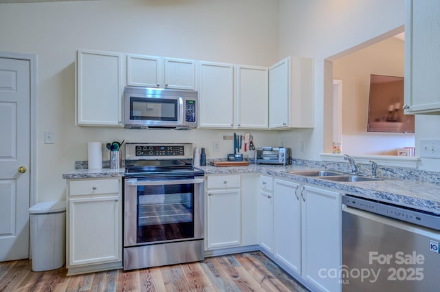 1975 8th Street Ln SE, Hickory, NC 28602 - kitchen featuring stainless steel appliances, light wood finished floors, and white cabinets