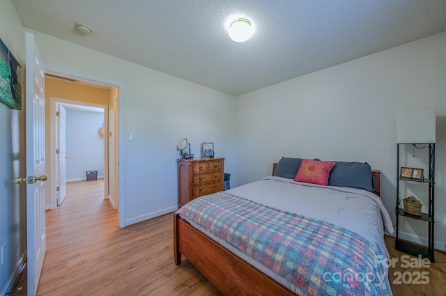 1975 8th Street Ln SE, Hickory, NC 28602 - bedroom with light wood-type flooring and a textured ceiling