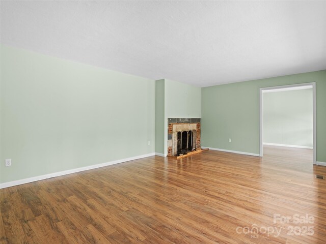 71 Auburn Park Dr, Waynesville, NC 28786 - unfurnished living room with light wood-type flooring and a brick fireplace