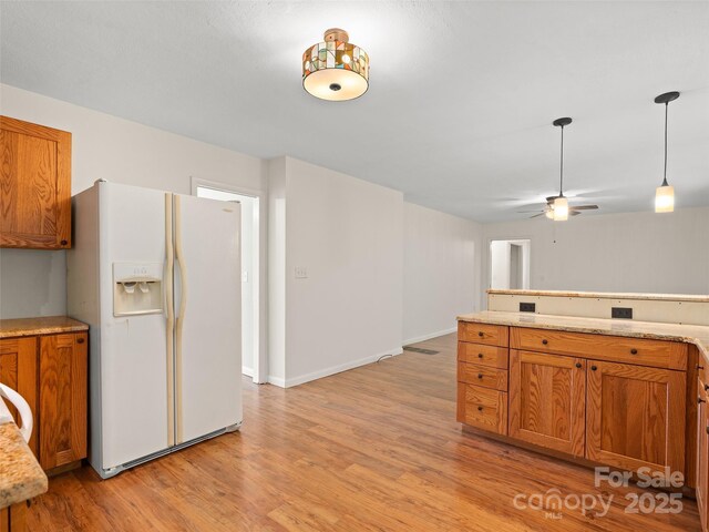 71 Auburn Park Dr, Waynesville, NC 28786 - kitchen featuring white refrigerator with ice dispenser, brown cabinets, light wood-style floors, ceiling fan, and decorative light fixtures