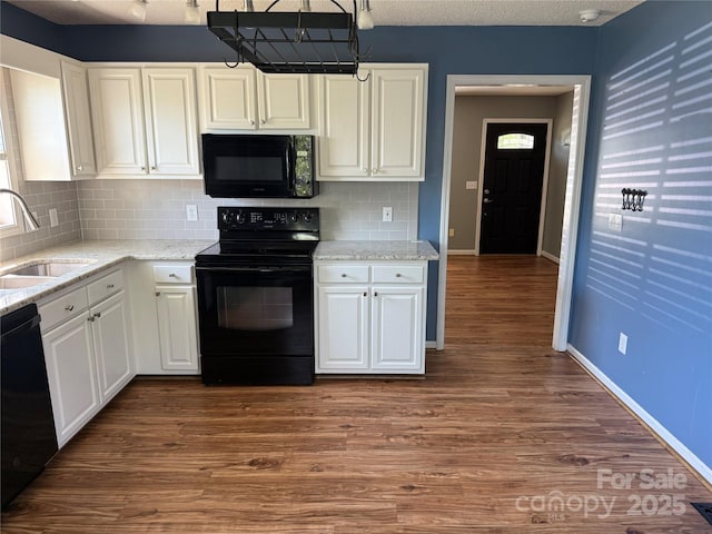 4870 Beckel Rd, Winston Salem, NC 27127 - kitchen featuring black appliances, decorative backsplash, white cabinetry, dark wood-style floors, and light stone countertops