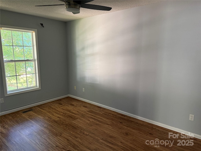 4870 Beckel Rd, Winston Salem, NC 27127 - empty room with ceiling fan, a textured ceiling, healthy amount of natural light, and dark wood-type flooring