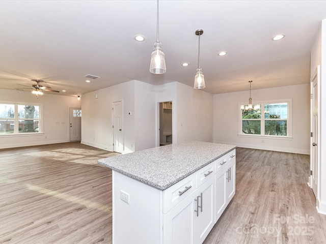 5613 Morgan Mill Rd, Monroe, NC 28110 - kitchen with recessed lighting, healthy amount of natural light, a kitchen island, light wood-type flooring, and white cabinetry