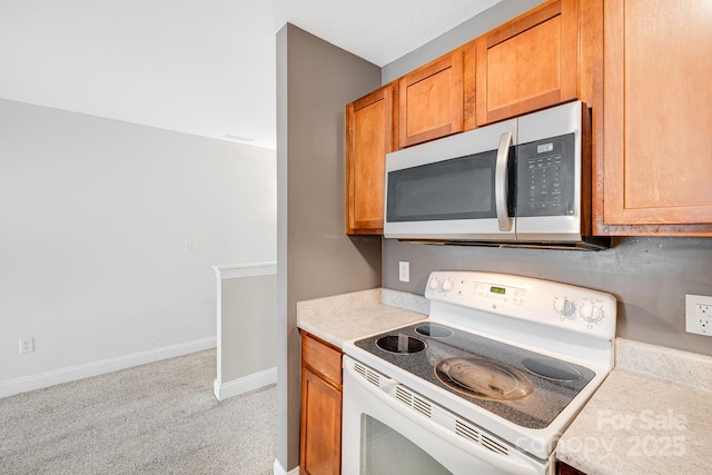 64 Foxden Dr Unit 201, Fletcher, NC 28732 - kitchen featuring white range with electric cooktop, stainless steel microwave, light countertops, and light colored carpet