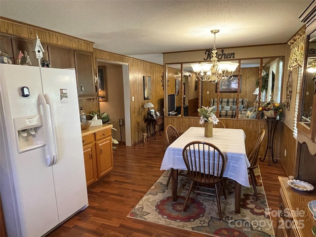3403 Beaty Rd, Gastonia, NC 28056 - dining area featuring wood walls, dark wood-style floors, a chandelier, and a textured ceiling