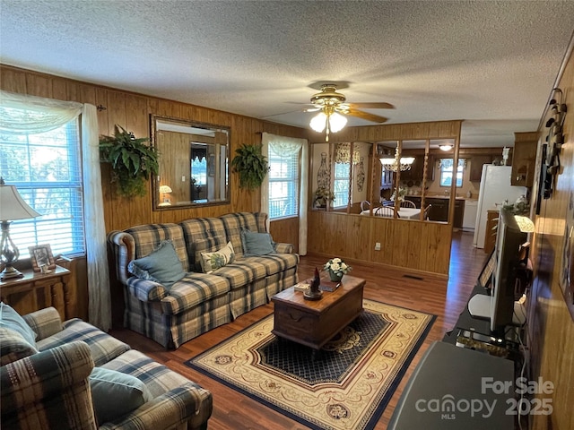 3403 Beaty Rd, Gastonia, NC 28056 - living room with healthy amount of natural light, a textured ceiling, wood walls, a ceiling fan, and wood finished floors