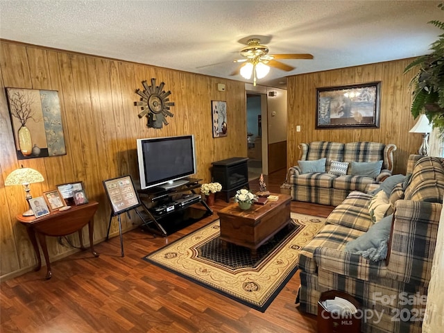 3403 Beaty Rd, Gastonia, NC 28056 - living room featuring wooden walls, a textured ceiling, wood finished floors, ceiling fan, and a wood stove