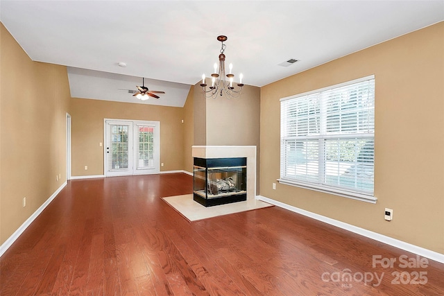 4580 Antelope Ln, Charlotte, NC 28269 - unfurnished living room featuring wood finished floors, ceiling fan, a multi sided fireplace, a chandelier, and lofted ceiling