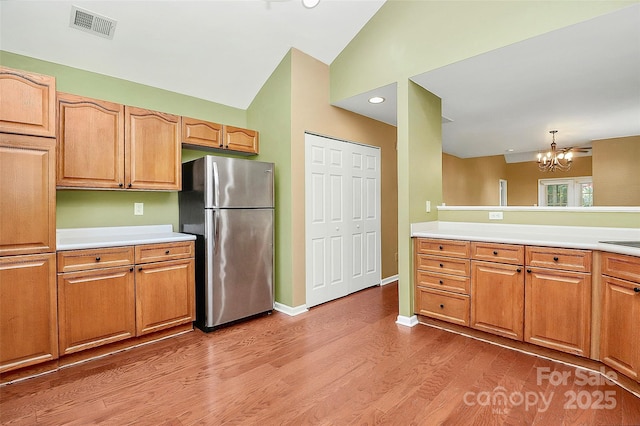 4580 Antelope Ln, Charlotte, NC 28269 - kitchen featuring freestanding refrigerator, a chandelier, light countertops, light wood-type flooring, and high vaulted ceiling