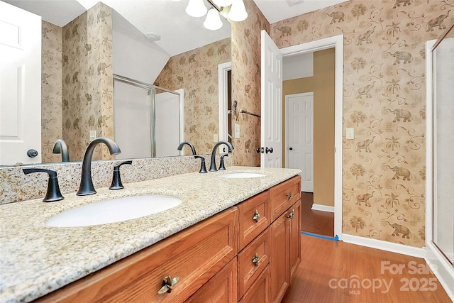 4580 Antelope Ln, Charlotte, NC 28269 - bathroom featuring wood finished floors, wallpapered walls, a stall shower, and double vanity