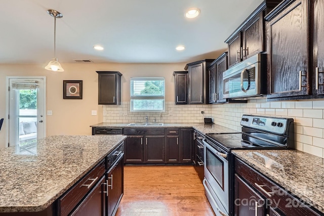 10920 Dapple Grey Ln, Charlotte, NC 28213 - kitchen featuring stainless steel appliances, light stone counters, light wood-style flooring, dark brown cabinetry, and recessed lighting