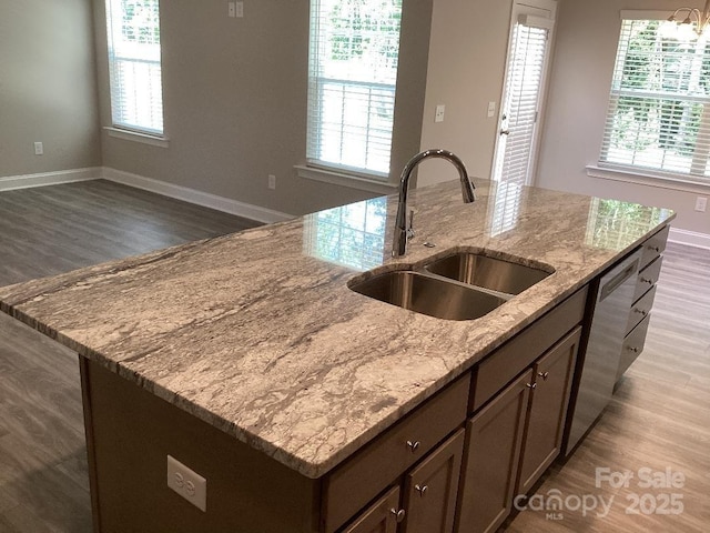 5126 Rocky River Crossing Rd, Harrisburg, NC 28075 - kitchen featuring a center island with sink, stainless steel dishwasher, wood finished floors, and light stone countertops