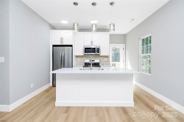 226 N Columbia Ave, Rock Hill, SC 29730 - kitchen with stainless steel appliances, light wood-style flooring, backsplash, a center island with sink, and light countertops