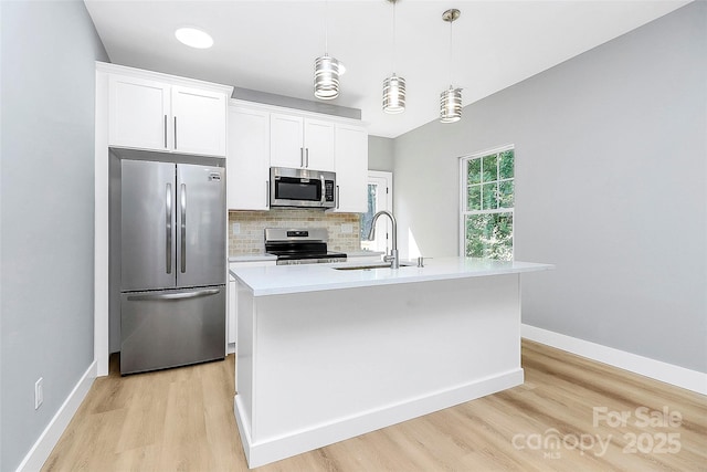226 N Columbia Ave, Rock Hill, SC 29730 - kitchen with appliances with stainless steel finishes, light wood-style flooring, backsplash, light countertops, and a center island with sink