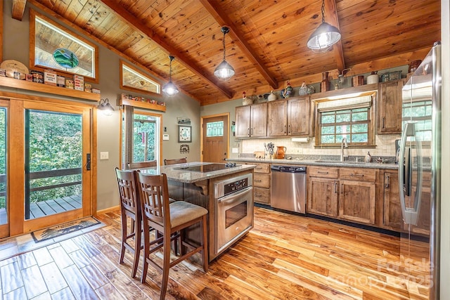 821 Old Chestnut Mountain Rd, Newland, NC 28645 - kitchen featuring appliances with stainless steel finishes, light wood-style flooring, wood ceiling, backsplash, and a kitchen island