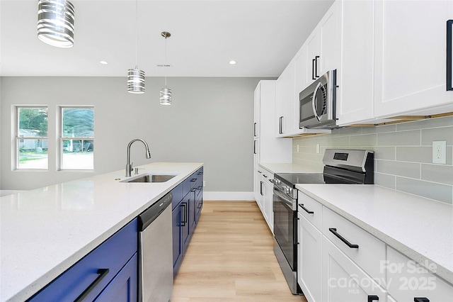 5516 Old York Rd, Rock Hill, SC 29732 - kitchen with stainless steel appliances, blue cabinetry, light countertops, white cabinets, and light wood-style flooring