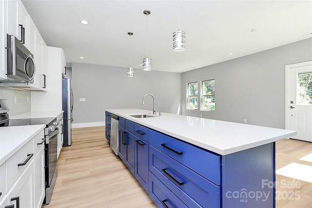 5516 Old York Rd, Rock Hill, SC 29732 - kitchen featuring appliances with stainless steel finishes, blue cabinetry, light wood-type flooring, white cabinets, and light countertops