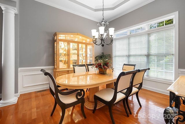 15933 Glen Miro Dr, Huntersville, NC 28078 - dining space featuring ornate columns, light wood finished floors, crown molding, wainscoting, and a chandelier
