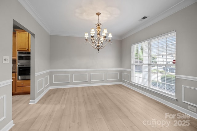 1504 Jekyll Ln, Waxhaw, NC 28173 - empty room with light wood-style flooring, a chandelier, crown molding, and wainscoting