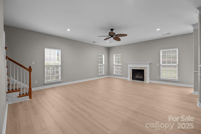 1504 Jekyll Ln, Waxhaw, NC 28173 - unfurnished living room featuring a ceiling fan, a premium fireplace, light wood-style flooring, stairway, and recessed lighting