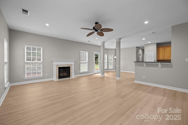 1504 Jekyll Ln, Waxhaw, NC 28173 - unfurnished living room with ornate columns, a ceiling fan, healthy amount of natural light, light wood-type flooring, and recessed lighting