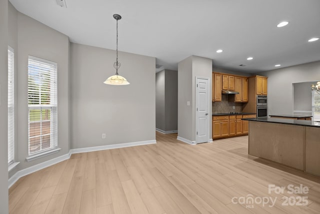 1504 Jekyll Ln, Waxhaw, NC 28173 - kitchen featuring dark countertops, light wood-type flooring, backsplash, double oven, and recessed lighting
