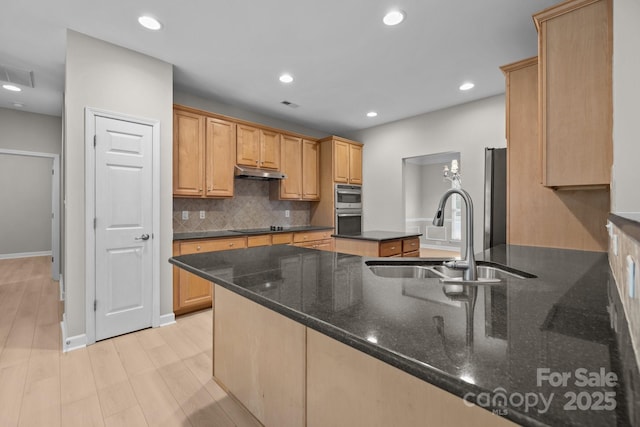 1504 Jekyll Ln, Waxhaw, NC 28173 - kitchen featuring under cabinet range hood, backsplash, stainless steel double oven, dark stone countertops, and recessed lighting