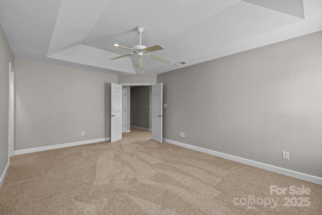 1504 Jekyll Ln, Waxhaw, NC 28173 - unfurnished bedroom featuring light colored carpet, ceiling fan, and a tray ceiling