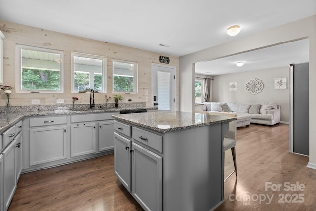 712 Coventry Dr, Albemarle, NC 28001 - kitchen featuring open floor plan, a center island, a kitchen breakfast bar, light stone countertops, and dark wood-style flooring