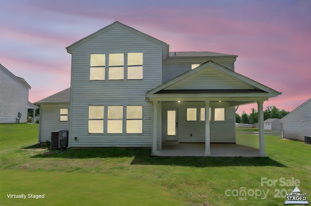 712 Coventry Dr, Albemarle, NC 28001 - back of property at dusk featuring a lawn and a patio area