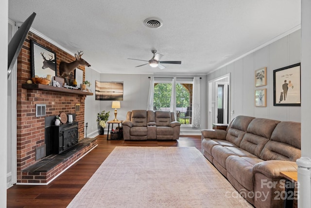 1560 Lafayette Ave, Hudson, NC 28638 - living area with crown molding, a ceiling fan, dark wood finished floors, a wood stove, and a textured ceiling