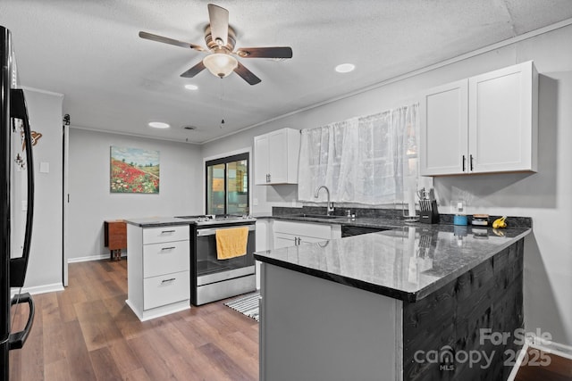 1560 Lafayette Ave, Hudson, NC 28638 - kitchen featuring stainless steel range with electric stovetop, a peninsula, white cabinetry, ceiling fan, and wood finished floors