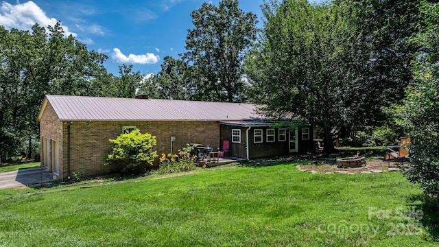1560 Lafayette Ave, Hudson, NC 28638 - view of front of property with an outdoor fire pit, a front yard, brick siding, and a garage